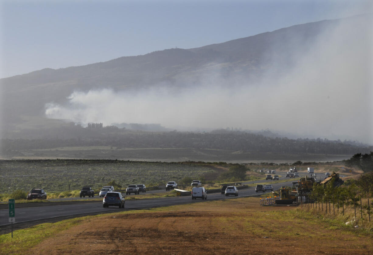 Smoke blows across the slope of Haleakala volcano on Maui, Hawaii, as a fire burns in Maui's upcountry region on Tuesday, Aug. 8. 2023. Several Hawaii communities were forced to evacuate from wildfires that destroyed at least two homes as of Tuesday as a dry season mixed with strong wind gusts made for dangerous fire conditions.