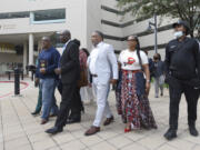 FILE - Attorney Ben Crump, second from left, walks with Ron Lacks, left, Alfred Lacks Carter, third from left, both grandsons of Henrietta Lacks, and other descendants of Lacks, outside the federal courthouse in Baltimore, Oct. 4, 2021. The family of Henrietta Lacks is settling a lawsuit against a biotechnology company it accuses of improperly profiting from her cells. Their federal lawsuit in Baltimore claimed Thermo Fisher Scientific has made billions from tissue taken without the Black woman's consent from her cervical cancer tumor.