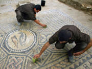 Prisoners work on a nearly 1,800-year-old decorated floor from an early Christian prayer hall discovered by Israeli archaeologists on Nov. 6, 2005, in the Megiddo prison in Tel Megiddo, Israel. Israeli officials are considering uprooting the mosaic and loaning it to the controversial Museum of the Bible in Washington, D.C.