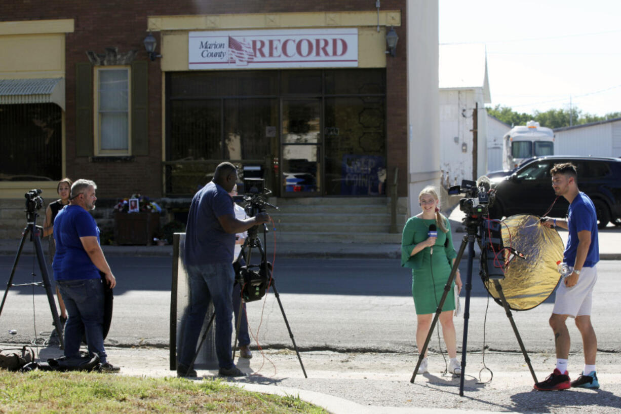 Television reporters and videographers from stations across the region prepare to do reports on the aftermath of local police raids on the Marion County Record, Wednesday, Aug. 16, 2023, in Marion, Kan. The raids on the newspaper's offices and the home of its publisher received international attention and were widely condemned by press freedom watchdog groups.