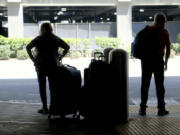 A couple waits for transportation at Terminal 5 at LAX on Wednesday, Aug. 30, 2023, in Los Angeles. With Labor Day weekend just days away, airports and roadways are expected to be busy as tens of thousands of Southern Californians travel out of town.