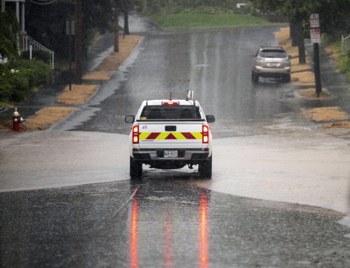 A pickup truck creeps though a flooded section of White Street in Lewiston, Maine on Tuesday, Aug. 8, 2023.