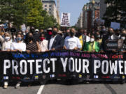 FILE - The Rev. Al Sharpton, foreground third from right, holds a banner with Martin Luther King, III, Rep. Sheila Jackson Lee, D-Texas, second from right, and Rep. Al Green, D-Texas, right, and others, during the march to call for sweeping protections against a further erosion of the Voting Rights Act of 1965, Saturday, Aug. 28, 2021, in Washington.