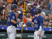 Seattle Mariners' Julio Rodriguez, left, is given a trident by Ty France after Rodriguez's solo home run against the Houston Astros during the third inning of a baseball game Friday, Aug. 18, 2023, in Houston.