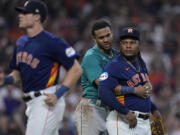 Seattle Mariners' Julio Rodriguez, center, pushes Houston Astros starting pitcher Framber Valdez, right, away from home plate after he hit Mariners' Jose Caballero, causing the benches to clear during the fifth inning of a baseball game, Saturday, Aug. 19, 2023, in Houston. (AP Photo/Kevin M.