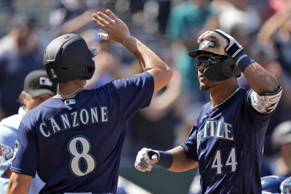 Seattle Mariners' Julio Rodriguez (44) celebrates with Dominic Canzone (8) after hitting a three-run home run during the eighth inning of a baseball game against the Kansas City Royals Thursday, Aug. 17, 2023, in Kansas City, Mo.