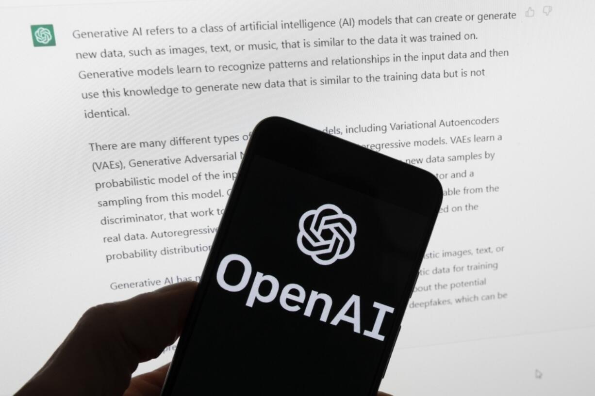 FILE - The OpenAI logo is seen on a mobile phone in front of a computer screen displaying output from ChatGPT, March 21, 2023, in Boston. Several news organizations, writers and photographers groups are seeking regulations to govern the fast-moving artificial intelligence technology that threatens upheavals for their businesses. In an open letter sent on Wednesday, Aug. 9, 2023, outlined priorities for setting rules on the technology, which is developing faster than regulators can keep up with.