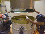 FILE - In this image provided by the U.S. Air Force, Airman 1st Class Jackson Ligon, left, and Senior Airman Jonathan Marinaccio, 341st Missile Maintenance Squadron technicians connect a re-entry system to a spacer on an intercontinental ballistic missile during a Simulated Electronic Launch-Minuteman test Sept. 22, 2020, at a launch facility near Malmstrom Air Force Base in Great Falls, Mont. The Air Force has temporarily closed two nuclear launch facilities after finding unsafe levels of a likely carcinogen in air samples at a Montana missile base where a striking number of men and women who served have reported cancer diagnoses. (Senior Airman Daniel Brosam/U.S.