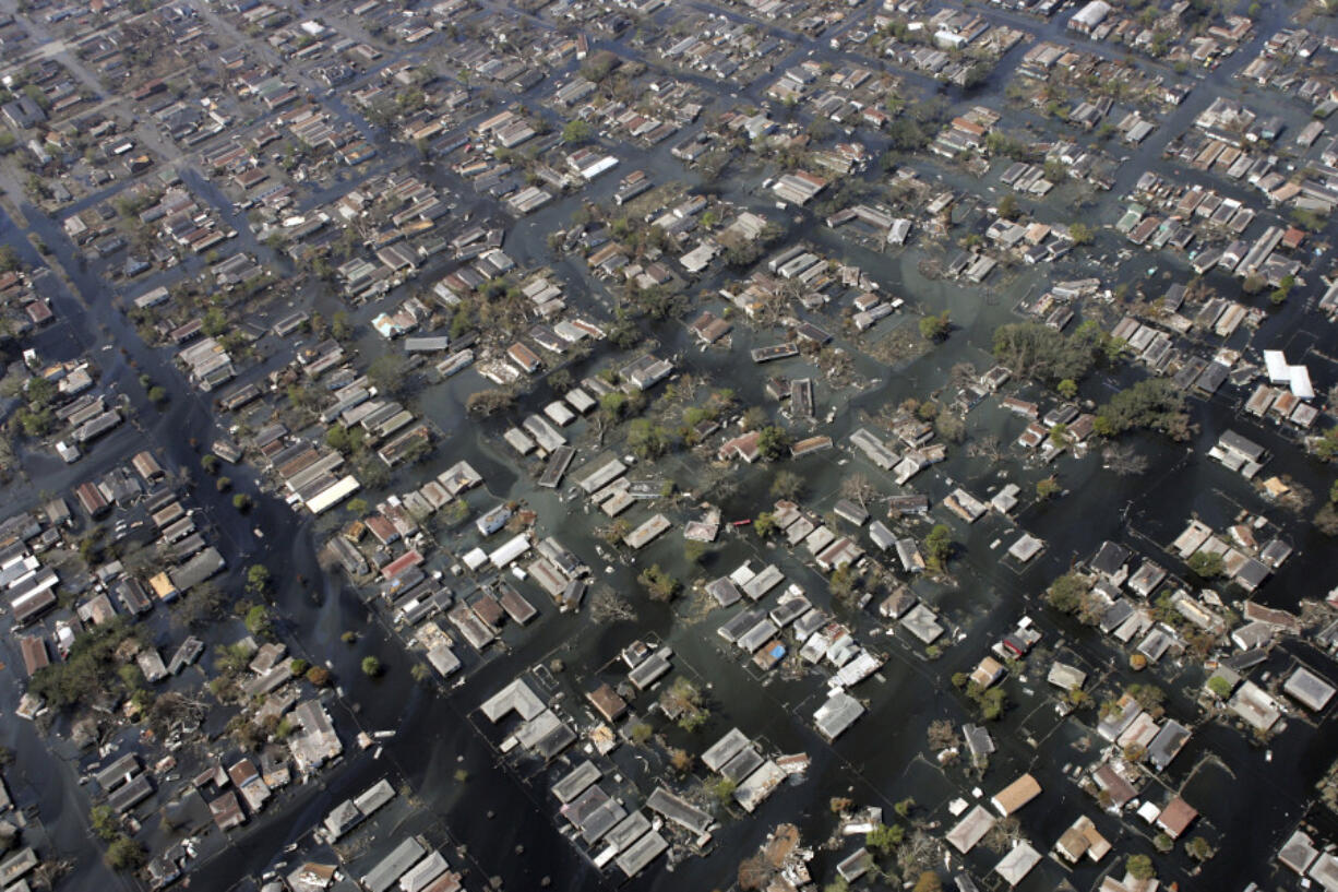 FILE - Homes remain surrounded by floodwaters in the aftermath of Hurricane Katrina, Sept. 11, 2005, in New Orleans. Hurricanes in the U.S. over last few decades killed thousands more people than meteorologists traditionally calculate and a disproportionate number of those victims are poor, vulnerable and minorities, according to a new epidemiological study released Wednesday, Aug. 16, 2023. (AP Photo/David J.