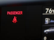 A seat belt warning sign for the right front passenger seat is displayed in a vehicle on Monday, Aug. 21, 2023. The Department of Transportation is proposing new rules designed to encourage seat belt use by car and truck passengers, including those sitting in the back seat. The new rules proposed by the National Highway Traffic Safety Administration would require manufacturers to equip vehicles with additional seat belt warning systems for the right front passenger and for rear seats to encourage increased seat belt use.