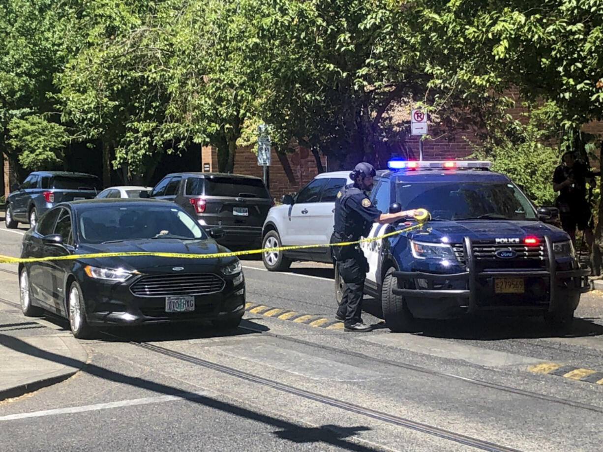 A police officer tapes off a crime scene on Saturday, July 22, 2023, after a shooting at Legacy Good Samaritan Medical Center in Portland, Ore. Gunfire erupted in a maternity unit of the Oregon hospital last weekend, fatally wounding an unarmed security guard and leading to renewed calls Monday, July 24,  to protect health care workers from increasing violence.