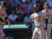 Baltimore Orioles' Cedric Mullins (31) celebrates as he greets Gunnar Henderson, left, after they both scored on his two-run home run against the Seattle Mariners during the 10th inning a baseball game, Sunday, Aug. 13, 2023, in Seattle.