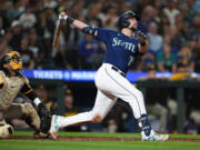 Seattle Mariners' Cal Raleigh watches his two-run home run next to San Diego Padres catcher Luis Campusano during the eighth inning of a baseball game Wednesday, Aug. 9, 2023, in Seattle.