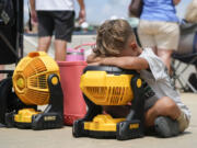 Braxton Hicks, 7, of Livingston, Texas, holds his face to a portable fan to cool off during the DYB, formerly Dixie Youth Baseball, Little League tournament in Ruston, La., Wednesday, Aug. 9, 2023. With climate change driving average global temperatures higher, organizers, players and spectators are having to pay closer attention to the heat.