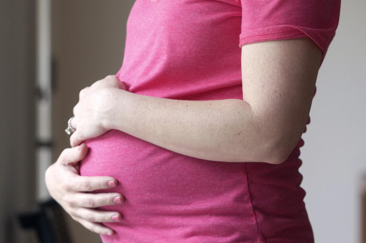 FILE - A pregnant woman stands for a portrait in Dallas, Thursday, May 18, 2023. On Friday, Aug. 4, 2023, U.S. health officials approved the first pill, Zurzuvae, specifically intended to treat severe depression after childbirth, a condition that affects thousands of new mothers in the U.S. each year.