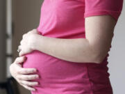 FILE - A pregnant woman stands for a portrait in Dallas, Thursday, May 18, 2023. On Friday, Aug. 4, 2023, U.S. health officials approved the first pill, Zurzuvae, specifically intended to treat severe depression after childbirth, a condition that affects thousands of new mothers in the U.S. each year.