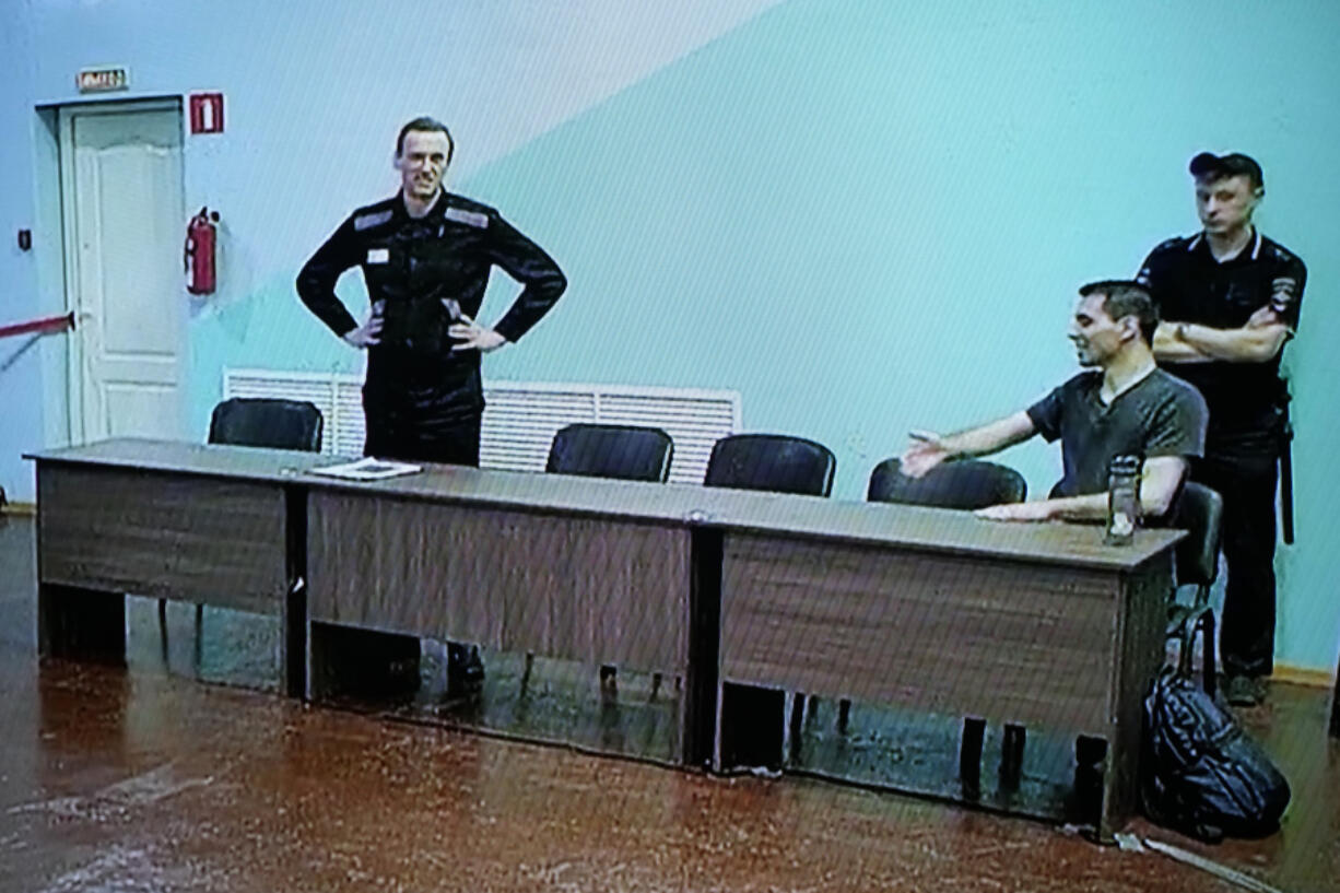 Russian opposition leader Alexei Navalny, left, and his associate Daniel Kholodny are seen at a TV screen as they appear in a video link provided by the Russian Federal Penitentiary Service, during a hearing in the colony, in Melekhovo, Vladimir region, about 260 kilometers (163 miles) northeast of Moscow, Russia, on Friday, Aug. 4, 2023. Navalny on Friday was convicted on extremism charges and sentenced to 19 years in prisons, in the harshest ruling against the imprisoned Kremlin critic to date.