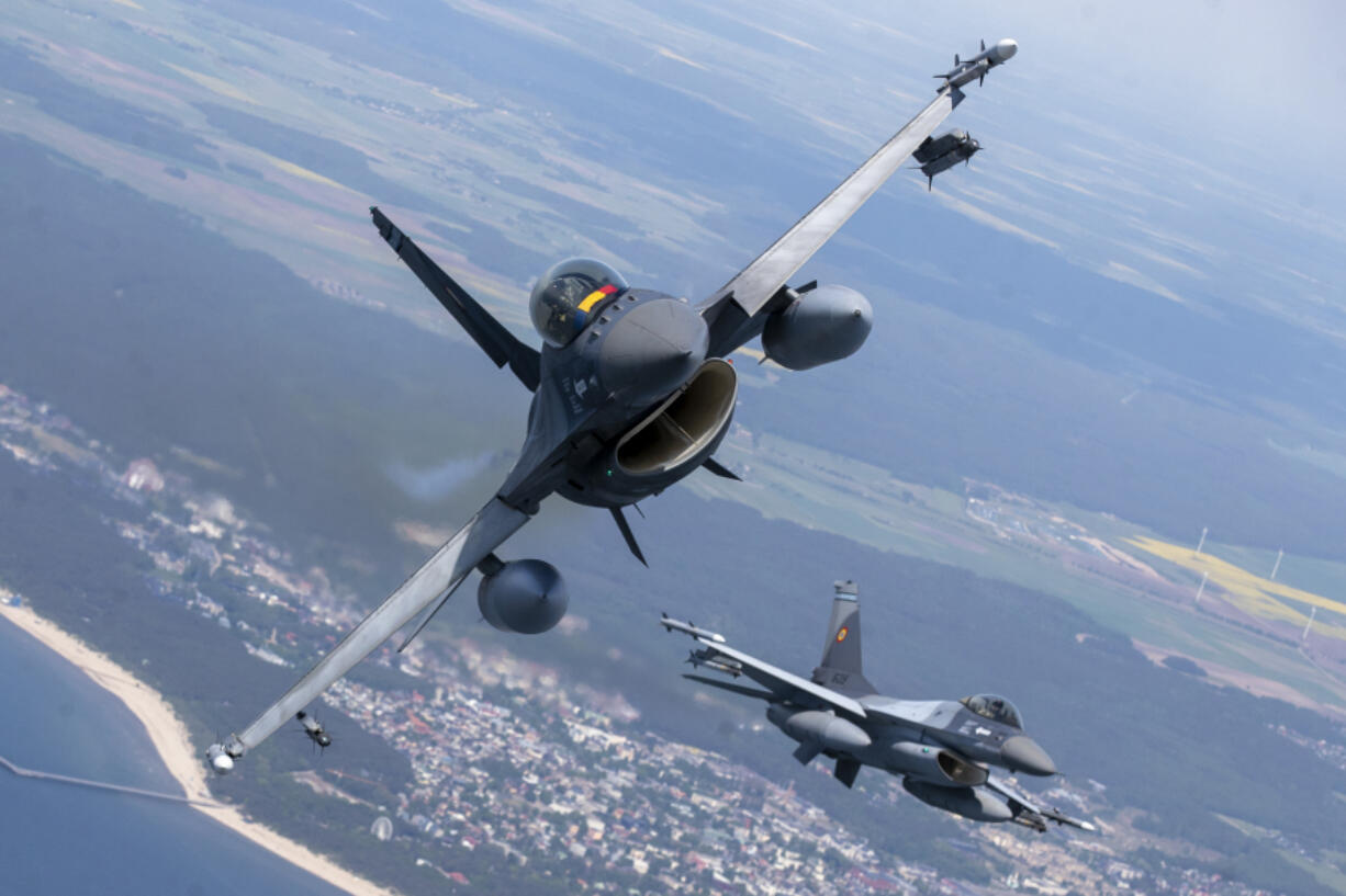 FILE - A Romanian Air Force F- 16s military fighter jet, left, and a Portuguese Air Force F- 16s military fighter jets participating in NATO's Baltic Air Policing Mission operate over the Baltic Sea, Lithuanian airspace, on May 22, 2023. The United States has given its approval for the Netherlands to deliver F-16s to Ukraine, the Dutch defense minister said Friday, Aug. 18, 2023 in a major gain for Kyiv even though the fighter jets won't have an immediate impact on the almost 18-month war.