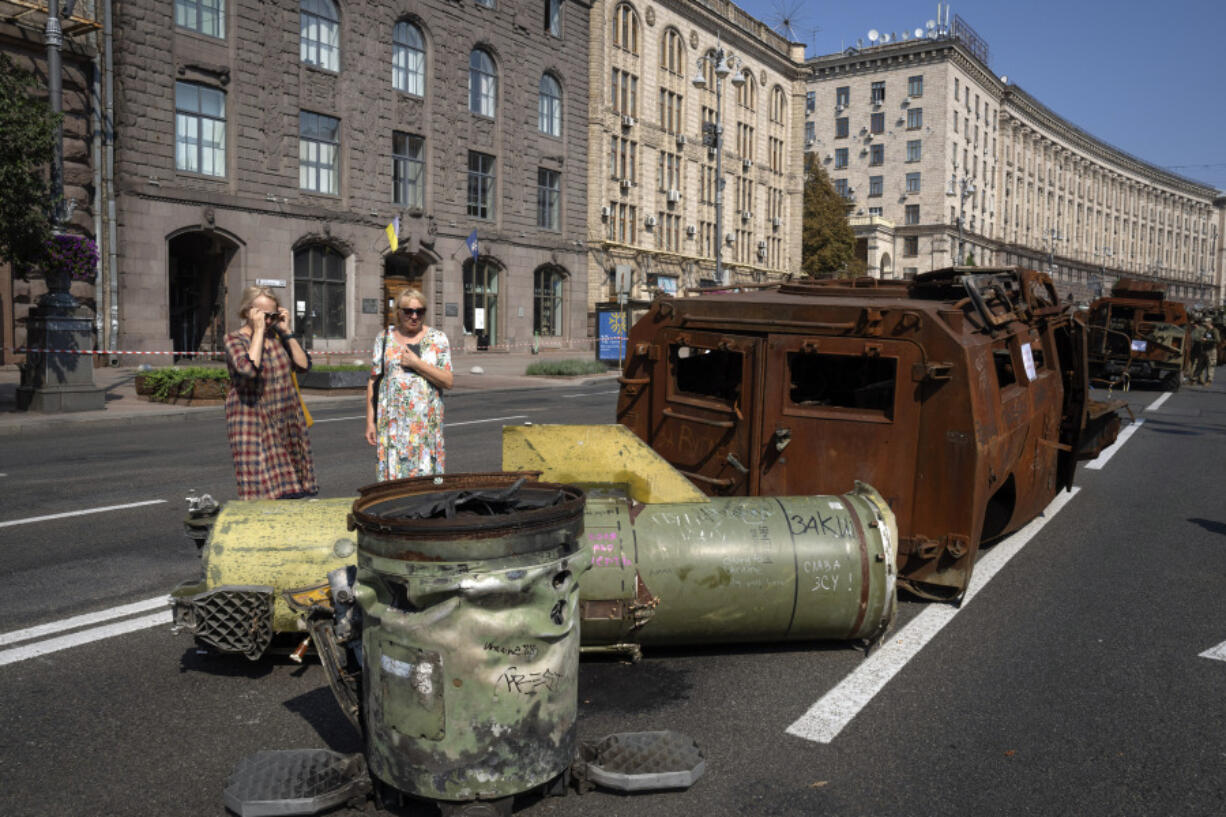 People look at fragments of the Russian rocket and destroyed military vehicles which have been displayed on a main street ahead of the Independence Day in Kyiv, Ukraine, Monday, Aug. 21, 2023. Ukraine marks the Independence Day on Aug. 24.