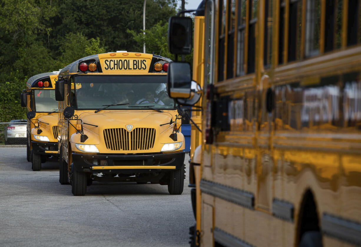 FILE - Jefferson County Public Schools buses packed with students make their way through the Detrick Bus Compound on the first day of school, Wednesday, Aug. 9, 2023, in Louisville, Ky. AlphaRoute, the company behind a disastrous change to a Kentucky city's school bus routes that resulted in more than a week of canceled classes, had similar problems in two cities in neighboring Ohio last year.