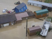 Vehicles and buildings are sit in floodwaters following heavy rains Monday, Aug. 28, 2023, in Chesapeake W.Va.