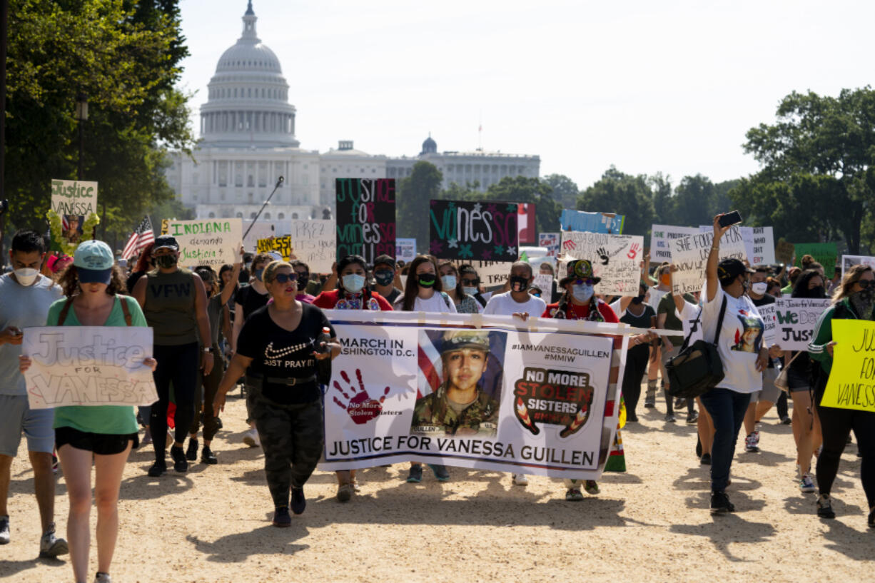 FILE - Supporters of the family of slain Army Spc. Vanessa Guill?n march to the White House along the National Mall as Capitol Hill is seen in the distance after a news conference in Washington, July 30, 2020. A federal judge has sentenced a Texas woman Monday, Aug. 14, 2023, to 30 years in prison for helping to dispose of the body of U.S. soldier Guill?n. The 2020 killing led to changes in how women in the military can report sexual abuse.