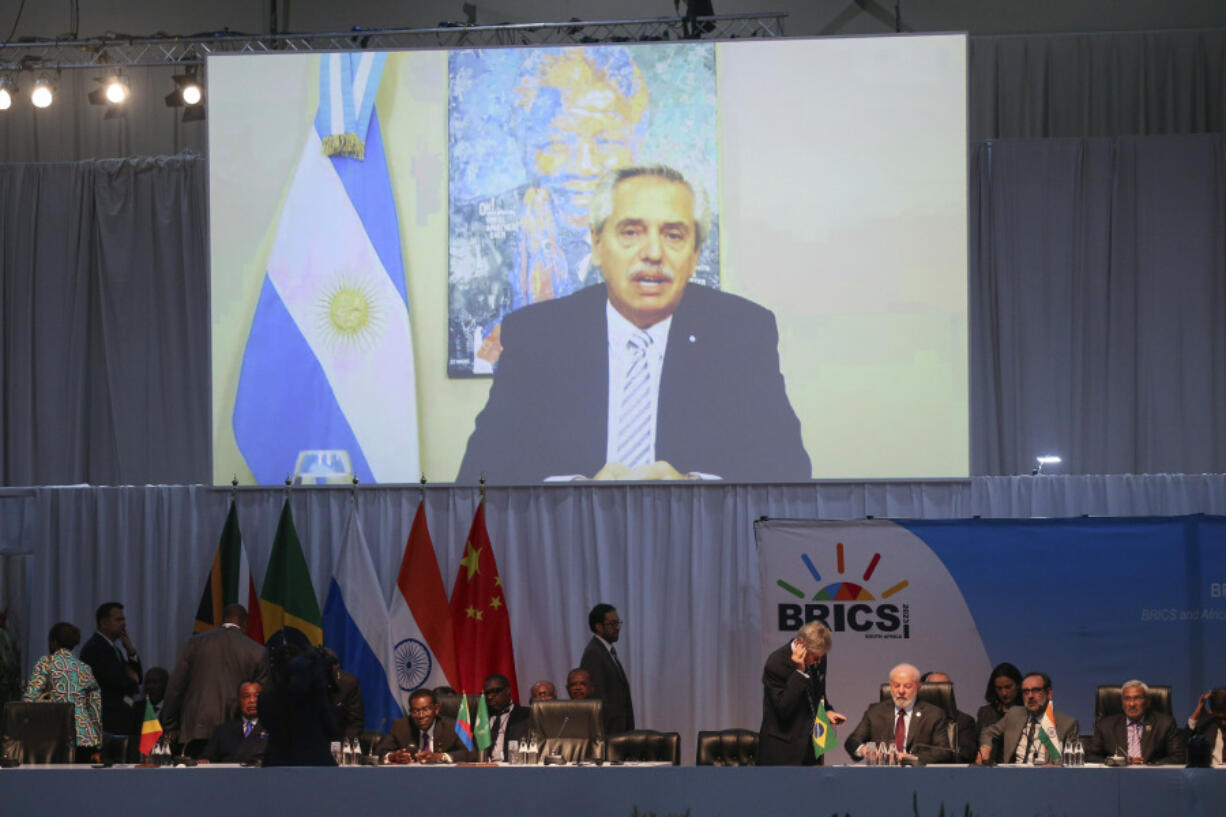 Argentine President Alberto Angel Fernandez appears on a screen as he addresses the 15th BRICS Summit, in Johannesburg, South Africa, Thursday, Aug. 24, 2023. The BRICS leaders announced that they would welcome six new members in January 2024: Iran, Argentina, Egypt, Ethiopia, Saudi Arabia and the United Arab Emirates.