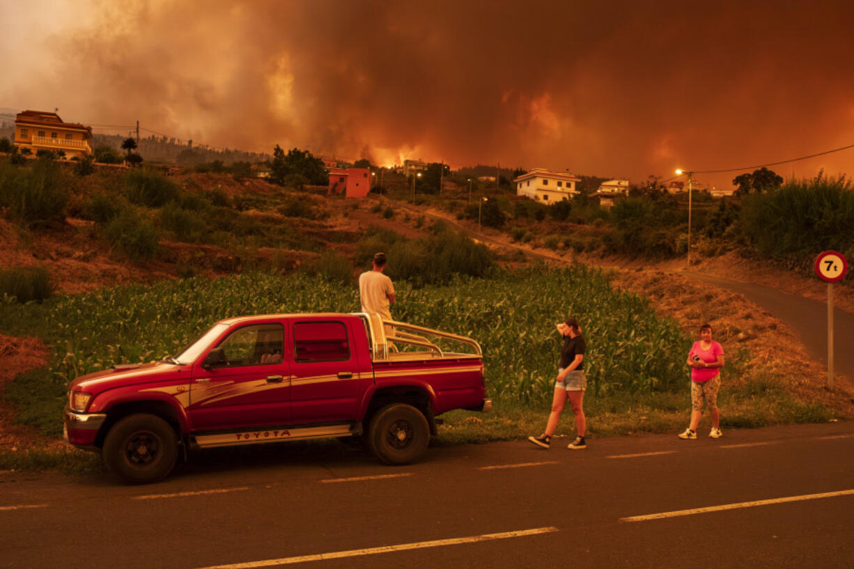 Local residents try to reach their houses in Benijos village as fire advances in La Orotava in Tenerife, Canary Islands, Spain on Saturday, Aug. 19, 2023. Firefighters have battled through the night to try to bring under control the worst wildfire in decades on the Spanish Canary Island of Tenerife, a major tourist destination. The fire in the north of the island started Tuesday night and has forced the evacuation or confinement of nearly 8,000 people.