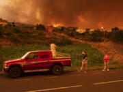 Local residents try to reach their houses in Benijos village as fire advances in La Orotava in Tenerife, Canary Islands, Spain on Saturday, Aug. 19, 2023. Firefighters have battled through the night to try to bring under control the worst wildfire in decades on the Spanish Canary Island of Tenerife, a major tourist destination. The fire in the north of the island started Tuesday night and has forced the evacuation or confinement of nearly 8,000 people.