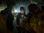 Emergency crews and firefighters work near the fire advancing through the forest toward the town of El Rosario in Tenerife, Canary Islands, Spain on Friday, Aug. 18, 2023. Officials say a wildfire is burning out of control through the Spanish Canary Island of Tenerife, affecting nearly 8,000 people who have been evacuated or ordered to stay indoors.