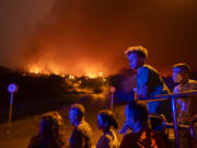 Local residents try to reach their houses in Benijos village as police block the area as fire advances in La Orotava in Tenerife, Canary Islands, Spain on Saturday, Aug. 19, 2023. Firefighters have battled through the night to try to bring under control the worst wildfire in decades on the Spanish Canary Island of Tenerife, a major tourist destination. The fire in the north of the island started Tuesday night and has forced the evacuation or confinement of nearly 8,000 people.