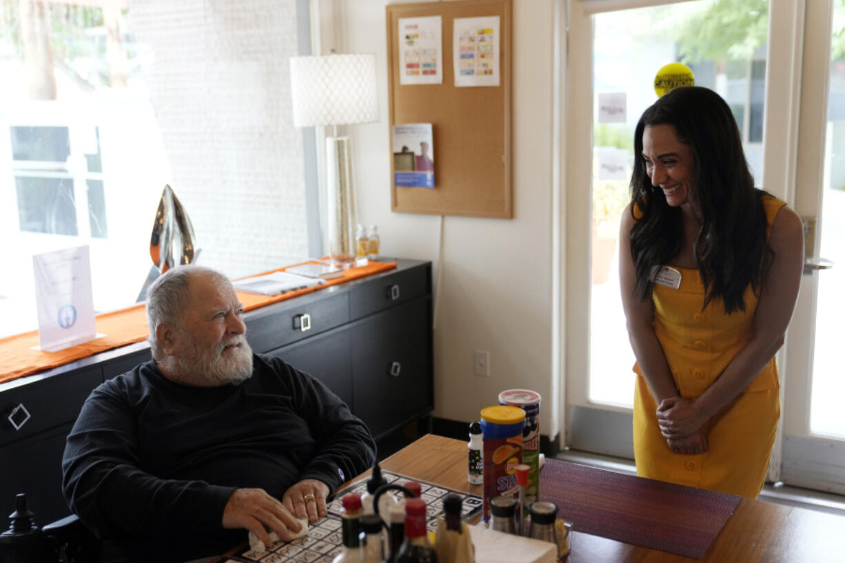 Lauren Kabakoff Vincent, right, interim executive director of Stonewall Gardens, talks with resident Billy Kurch at the LGBTQ+ assisted living facility, Tuesday, Aug. 15, 2023, in Palm Springs, Calif. The center's staff are required to go through sensitivity training to help make the center a more welcoming environment for residents, Vincent says. The training is key for making a more accepting environment for transgender residents and making them feel more at home.