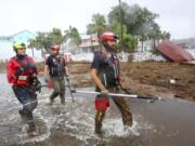 Rescue workers with Tidewater Disaster Response, from left, Zack Hoeth, Zack McCue, and Mike Foster, of Fairfax, Va., search SW 358 Highway for people in need of help Wednesday, Aug. 30, 2023, after the arrival of Hurricane Idalia. (Douglas R.