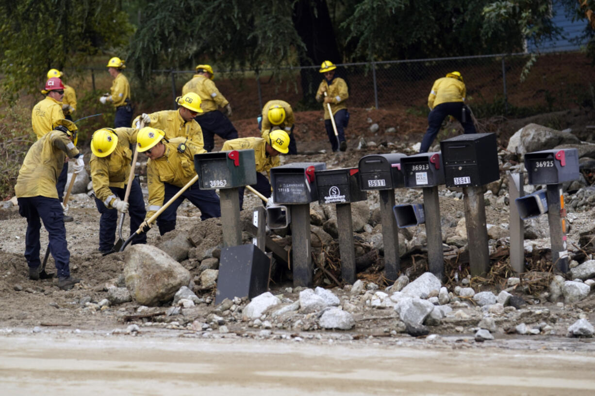 Members of Cal Fire Pilot Rock 6 crew out of Crestline, Calif., clear mud off the side of the road in the aftermath of Tropical Storm Hilary Monday, Aug. 21, 2023, in Yucaipa, Calif.