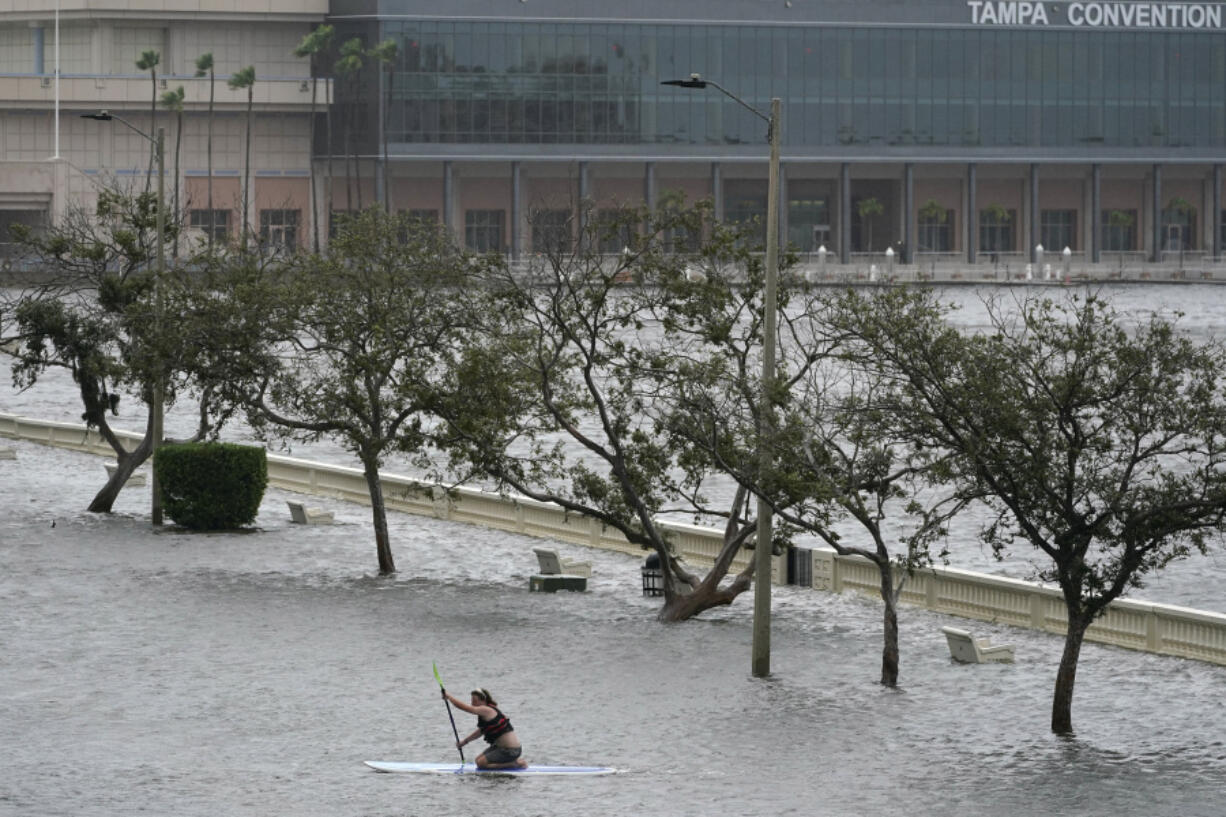 Zeke Pierce rides his paddle board down the middle of a flooded Bayshore Blvd in downtown in Tampa, Fla., Wednesday, Aug. 30, 2023.  Hurricane Idalia steamed toward Florida's Big Bend region Wednesday morning, threatening deadly storm surges and destructive winds in an area not accustomed to such pummeling.