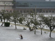 Zeke Pierce rides his paddle board down the middle of a flooded Bayshore Blvd in downtown in Tampa, Fla., Wednesday, Aug. 30, 2023.  Hurricane Idalia steamed toward Florida's Big Bend region Wednesday morning, threatening deadly storm surges and destructive winds in an area not accustomed to such pummeling.