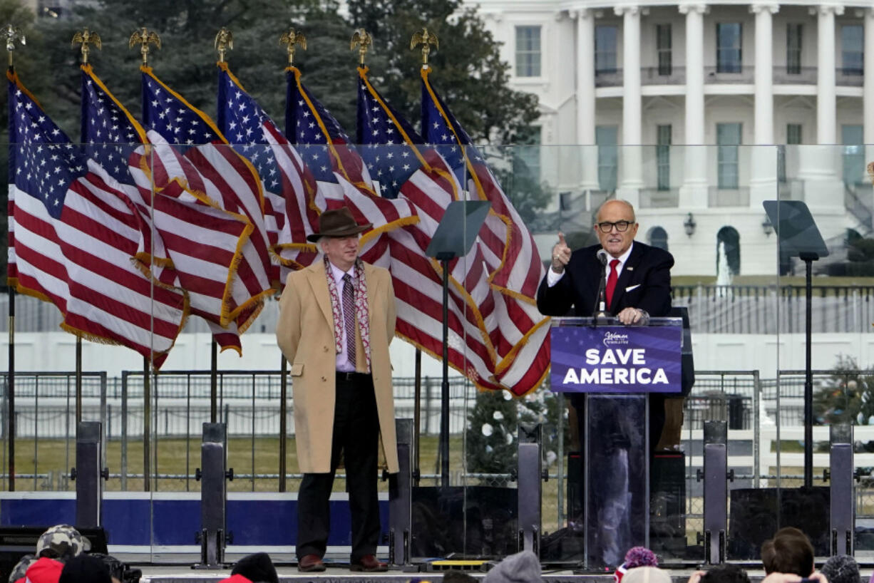 FILE - Chapman University law professor John Eastman stands at left as former New York Mayor Rudolph Giuliani speaks in Washington at a rally in support of President Donald Trump, called the "Save America Rally" on Jan. 6, 2021. The latest federal indictment against Donald Trump vividly illustrates the extent to which the former president's final weeks in office were consumed by a struggle over the law, with two determined groups of attorneys fighting it out as the future of American democracy hung in the balance.