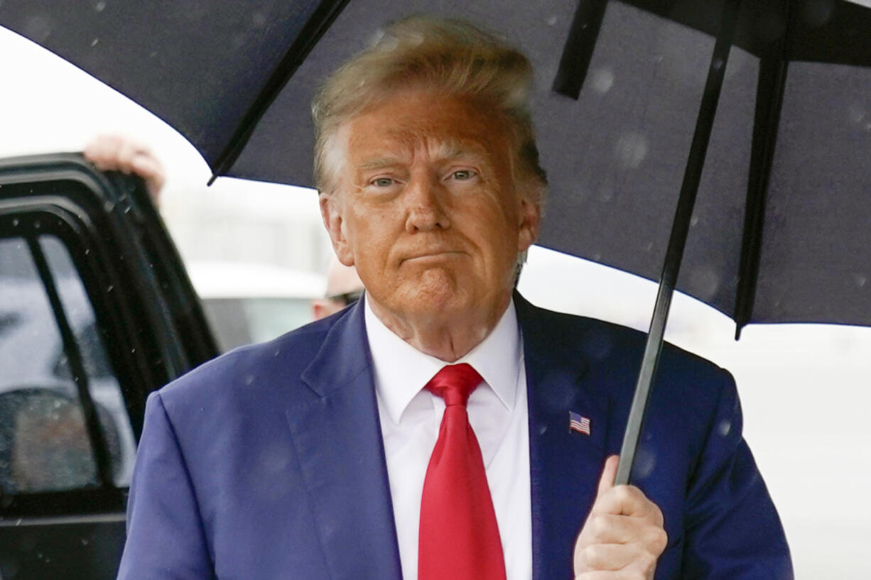 FILE - Former President Donald Trump walks to speak with reporters before boarding his plane at Ronald Reagan Washington National Airport, Aug. 3, 2023, in Arlington, Va. The federal judge overseeing the 2020 election conspiracy case against Donald Trump will hear arguments over a request by prosecutors for a protective order seeking to bar the former president from publicly disclosing evidence shared by the government.