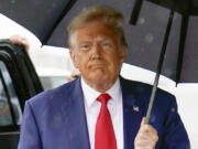 FILE - Former President Donald Trump walks to speak with reporters before boarding his plane at Ronald Reagan Washington National Airport, Aug. 3, 2023, in Arlington, Va. The federal judge overseeing the 2020 election conspiracy case against Donald Trump will hear arguments over a request by prosecutors for a protective order seeking to bar the former president from publicly disclosing evidence shared by the government.