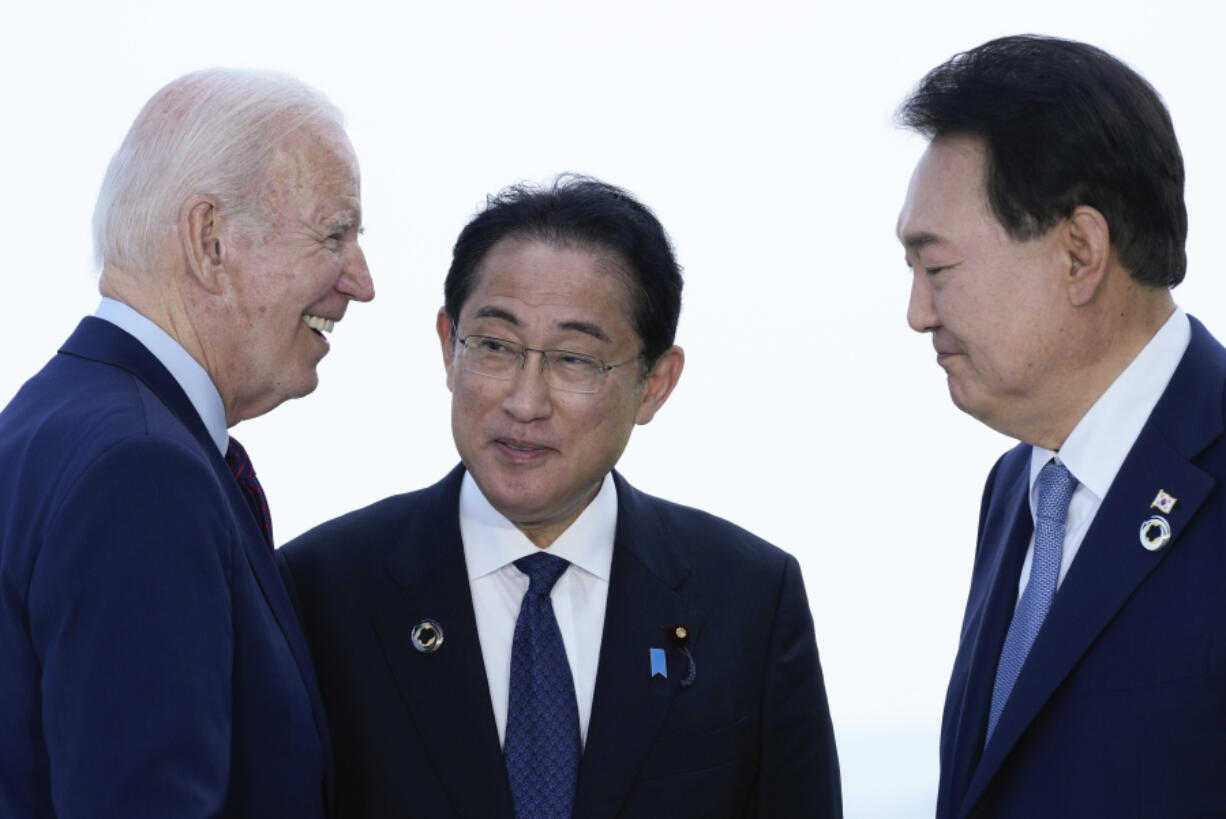 FILE - President Joe Biden, left, talks with Japan's Prime Minister Fumio Kishida and South Korean President Yoon Suk Yeol, right, ahead of a trilateral meeting on the sidelines of the G7 Summit in Hiroshima, Japan, Sunday, May 21, 2023. Biden aims to further tighten security and economic ties between Japan and South Korea, two nations that have struggled to stay on speaking terms, as he welcomes their leaders to the rustic Camp David presidential retreat Friday, Aug. 18.