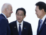 FILE - President Joe Biden, left, talks with Japan's Prime Minister Fumio Kishida and South Korean President Yoon Suk Yeol, right, ahead of a trilateral meeting on the sidelines of the G7 Summit in Hiroshima, Japan, Sunday, May 21, 2023. Biden aims to further tighten security and economic ties between Japan and South Korea, two nations that have struggled to stay on speaking terms, as he welcomes their leaders to the rustic Camp David presidential retreat Friday, Aug. 18.