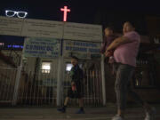 A woman carries a child past a cross and Christian quotes on the street in Ulaanbaatar, Mongolia on Tuesday, Aug. 29, 2023. When Pope Francis travels to Mongolia this week, he will in some ways be completing a mission begun by the 13th century Pope Innocent IV, who dispatched emissaries east to ascertain the intentions of the rapidly expanding Mongol Empire and beseech its leaders to halt the bloodshed and convert.