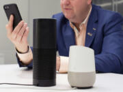 A man holds an iPhone next to an Amazon Echo, center, and a Google Home, right, in New York on June 14, 2018. A study published Monday, Aug. 28, 2023, in JAMA Network Open, says Alexa, Siri and other voice assistants could do a better job giving instructions on CPR to help bystanders respond in emergencies.