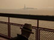 FILE - The Statue of Liberty, covered in a haze-filled sky, is photographed from the Staten Island Ferry, June 7, 2023, in New York. The smoke from Canadian wildfires that drifted into the U.S. led to a spike in people with asthma visiting emergency rooms -- particularly in the New York area. The U.S. Centers for Disease Control and Prevention published two studies Thursday, Aug. 24 about the health impacts of the smoke, which shrouded city skylines with an orange haze in late spring, and a medical journal also released a study this week.