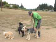 Scott Long of Vancouver, greets his dogs, 9-year-old Beni and 6-year-old Darby, right, at Ike Memorial Dog Park in Vancouver. Six years after an off-leash park in Washougal closed, the idea is  under consideration in Camas.