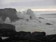 Waves pound a beach and structure between Depot Bay and Boiler Bay on the Oregon Coast.