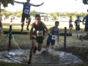 Oscar Hietpas of Stevenson, center, runs through the water pit at the 62nd annual Steve Maas Run-a-Ree on Friday at Hudson's Bay High School. The race is the traditional kickoff event for high school cross country in Southwest Washington.