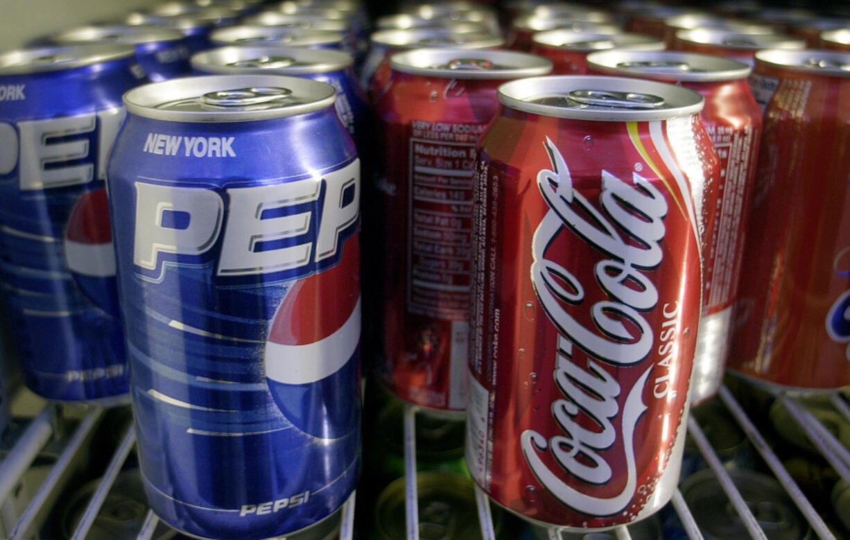 Cans of Pepsi and Coke are shown in 2005 in a news stand refrigerator display rack in New York. The "cola wars" between the two brands have been happening for decades.