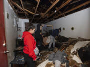 Jorge Amezquita, from right, cousin Adalene Castillo and girlfriend Cassandra Duarte look for a TV remote under debris after a tornado ripped the roof off the apartment on Jan. 24 at Beamer Place Apartments in Houston. When natural or man-made disasters happen, renters insurance can mean the difference between catastrophe and stability.