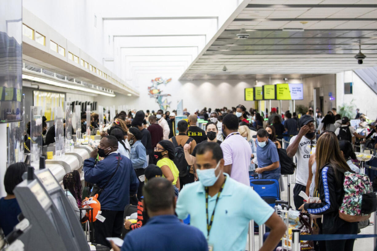 Passengers check in and wait by the Spirit Airlines ticket counter at Fort Lauderdale-Hollywood International Airport in Florida.